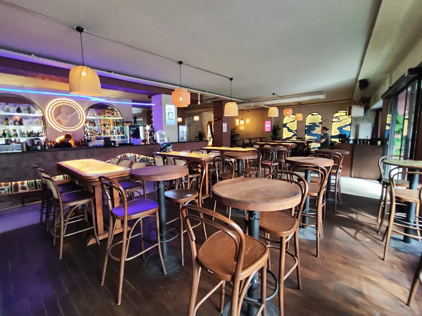 Bar counter and neon logo inside Benzin Social in Istanbul under coloured lighting