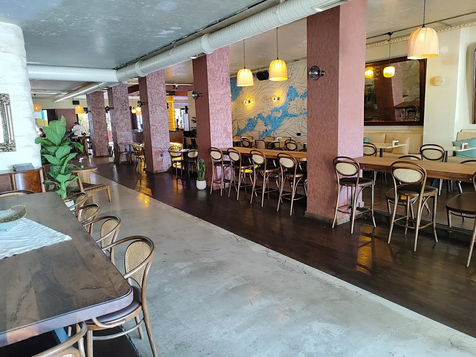 Open floor area between long tables inside Benzin Social in Istanbul