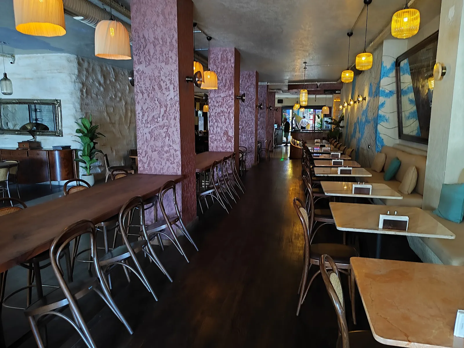 Long interior room at Benzin Social in Istanbul with pendant lamps and bench seating