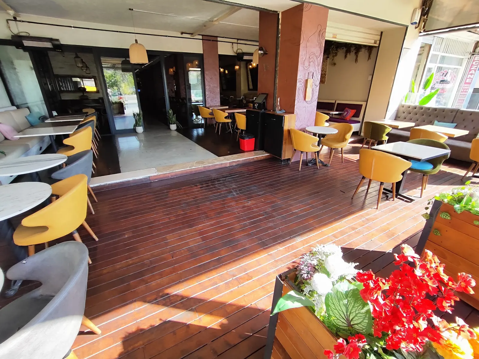 Wooden deck floor and lounge chairs in the front section of Benzin Social in Istanbul