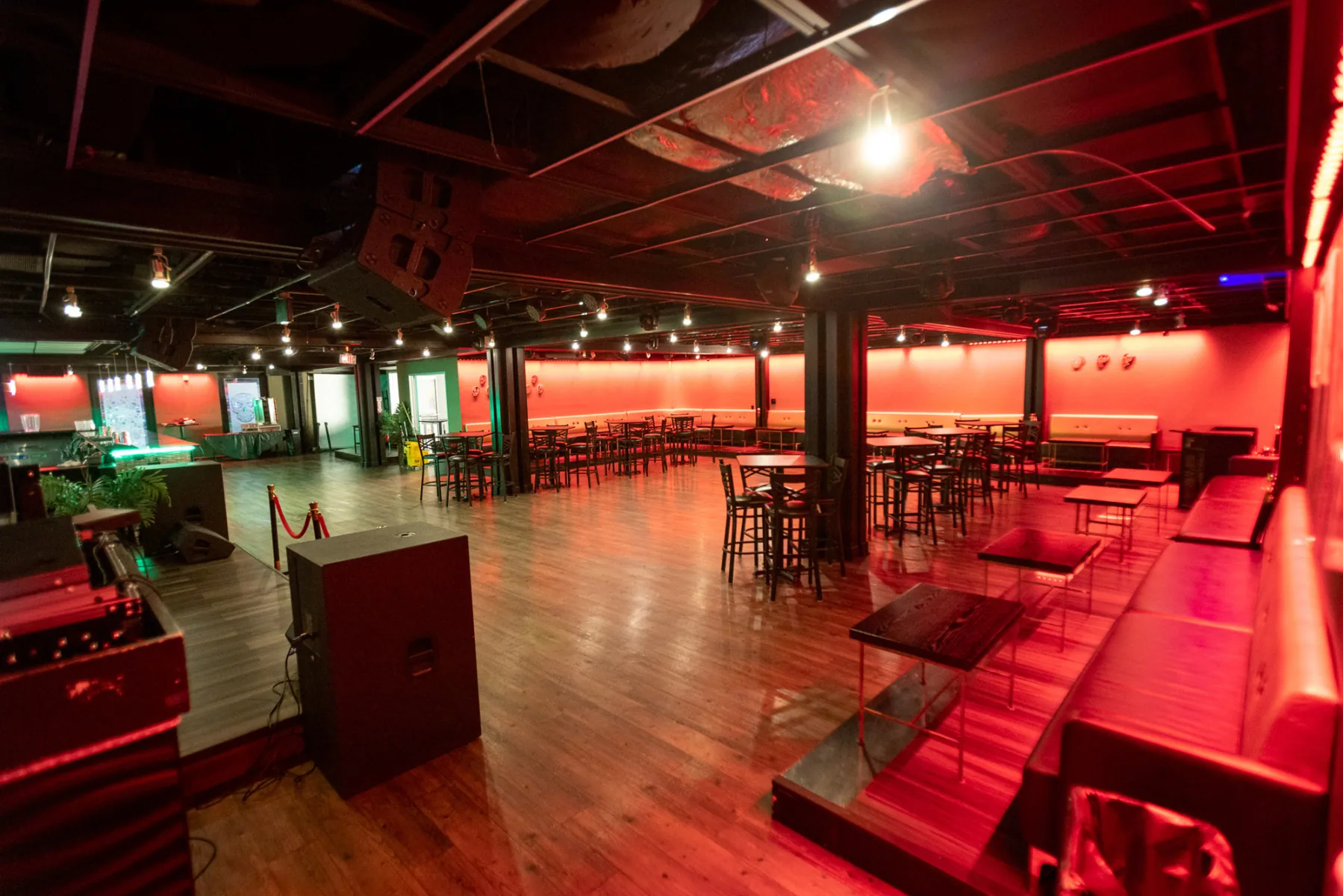 Open dance floor and lounge with red club lighting at La Catrina Lounge, Bethesda