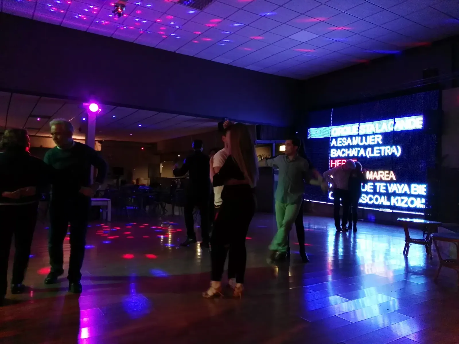 Couples dancing bachata and kizomba on the floor at Sala Ritmo Córdoba with LED display