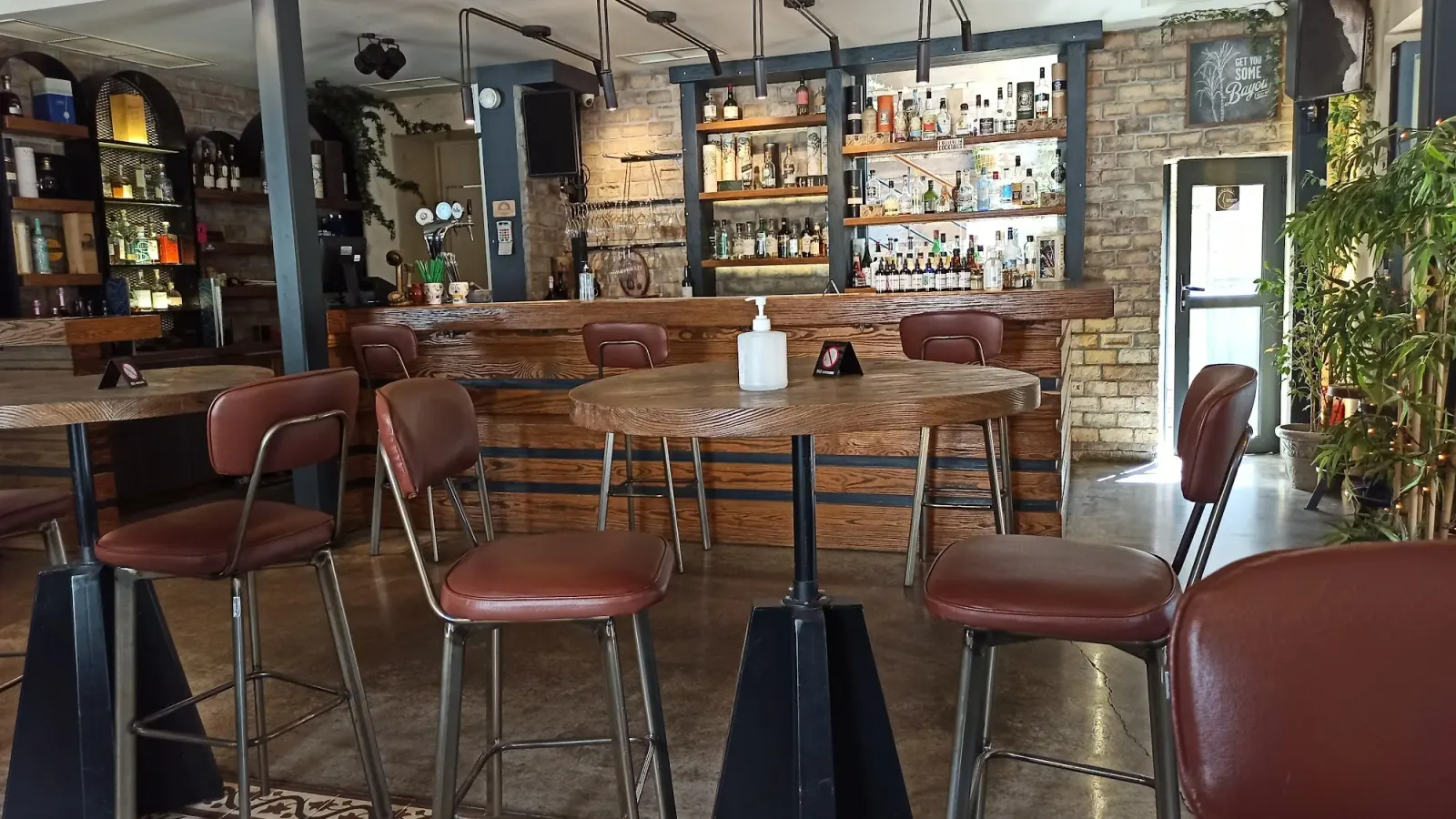 Manor House Athens interior with bar counter wooden stools and exposed brick wall
