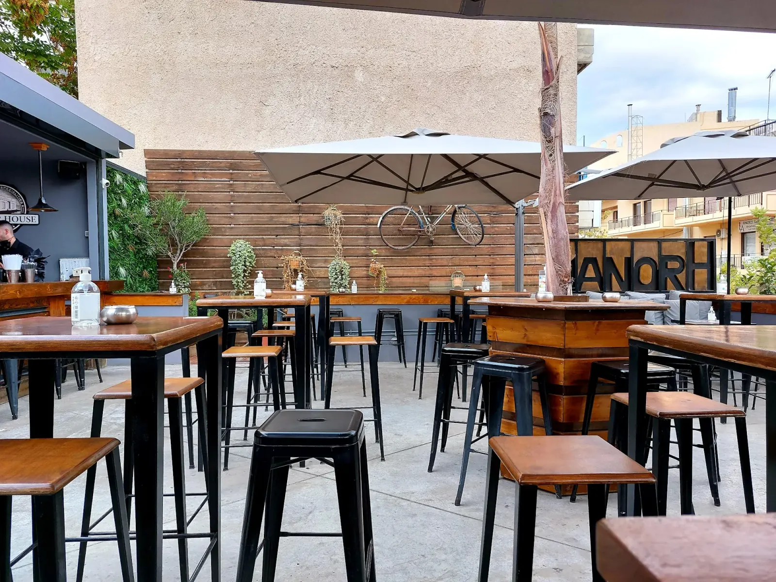 Manor House outdoor terrace in Athens with branded Manor signage visible on the wall
