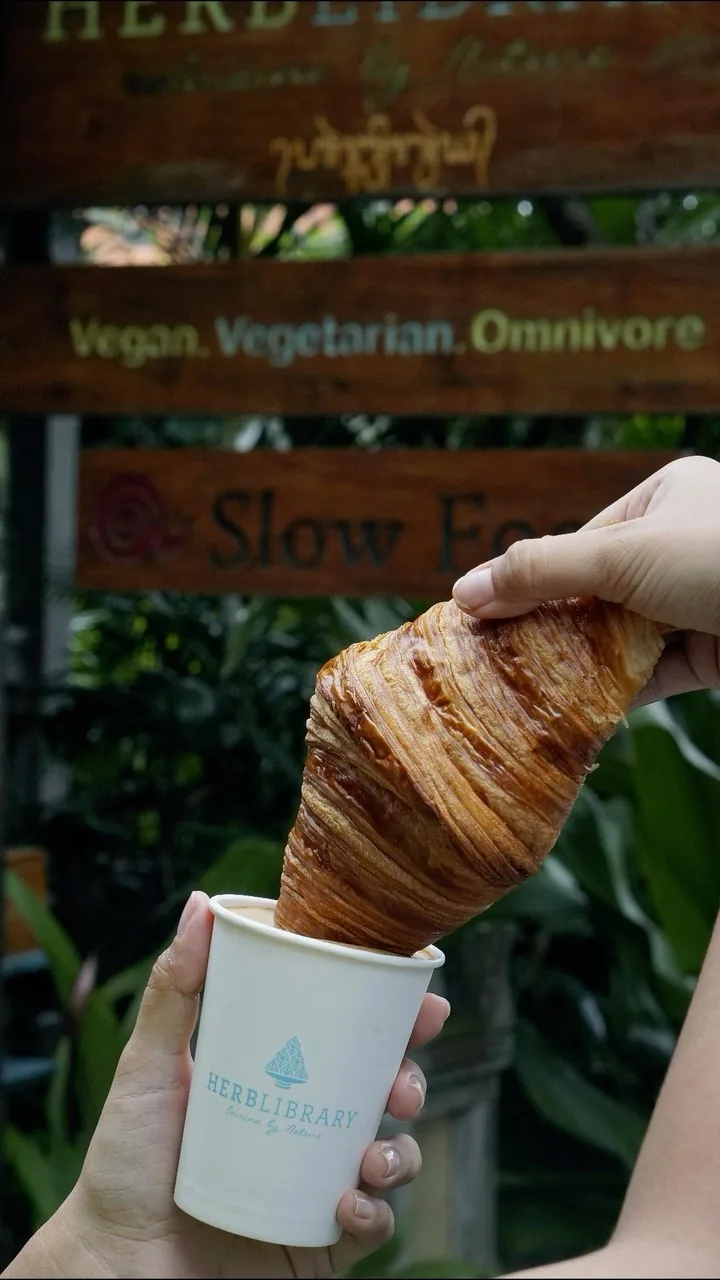 Herb Library Ubud entrance signage with croissant and branded coffee cup