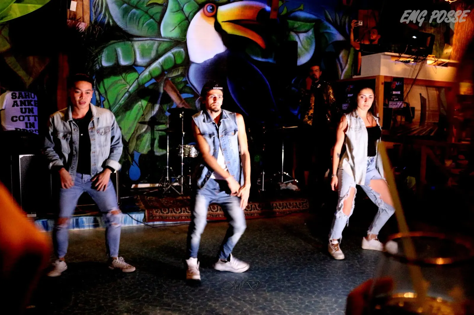 Performers dancing on stage in front of venue murals at Dandarì Disco Pub Italy