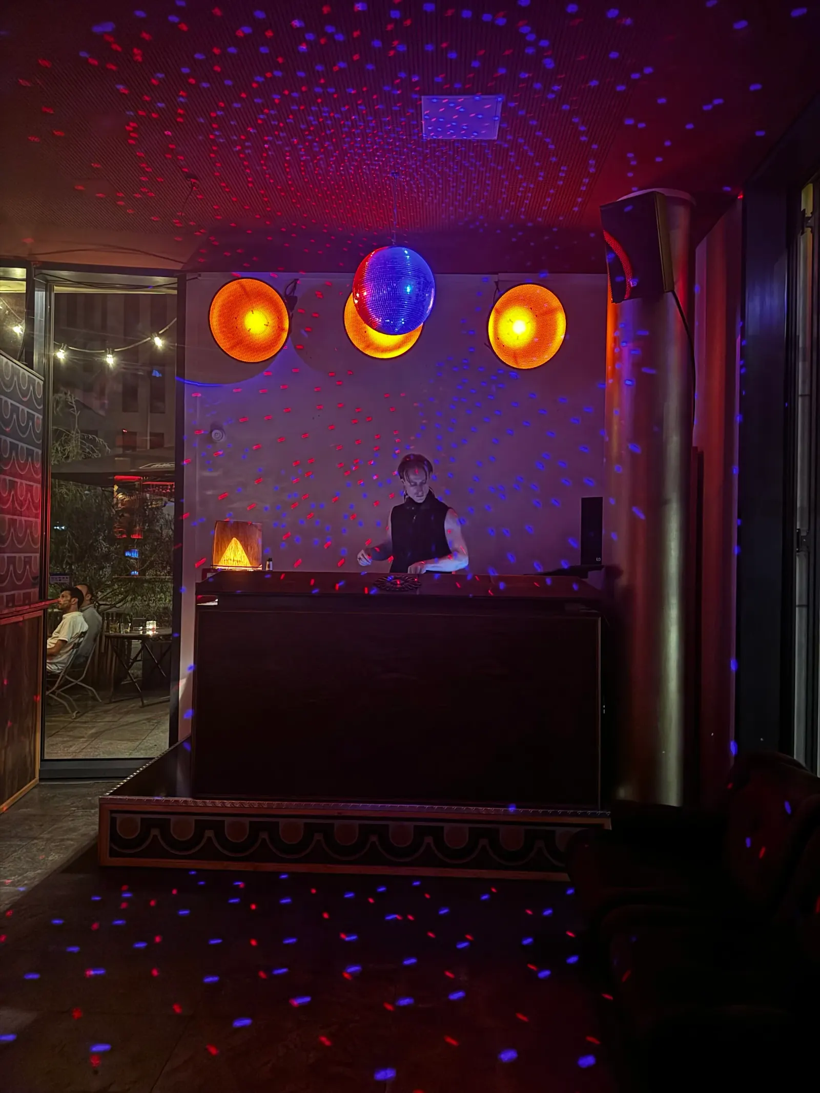 DJ booth with disco ball and party lighting at Wilder als erwartet Bar Berlin