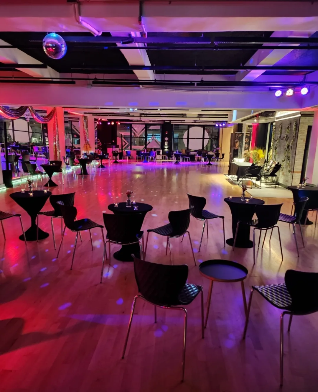 Disco ball, cocktail tables and purple lighting set up for a social night at EPA Dance Academy in New York