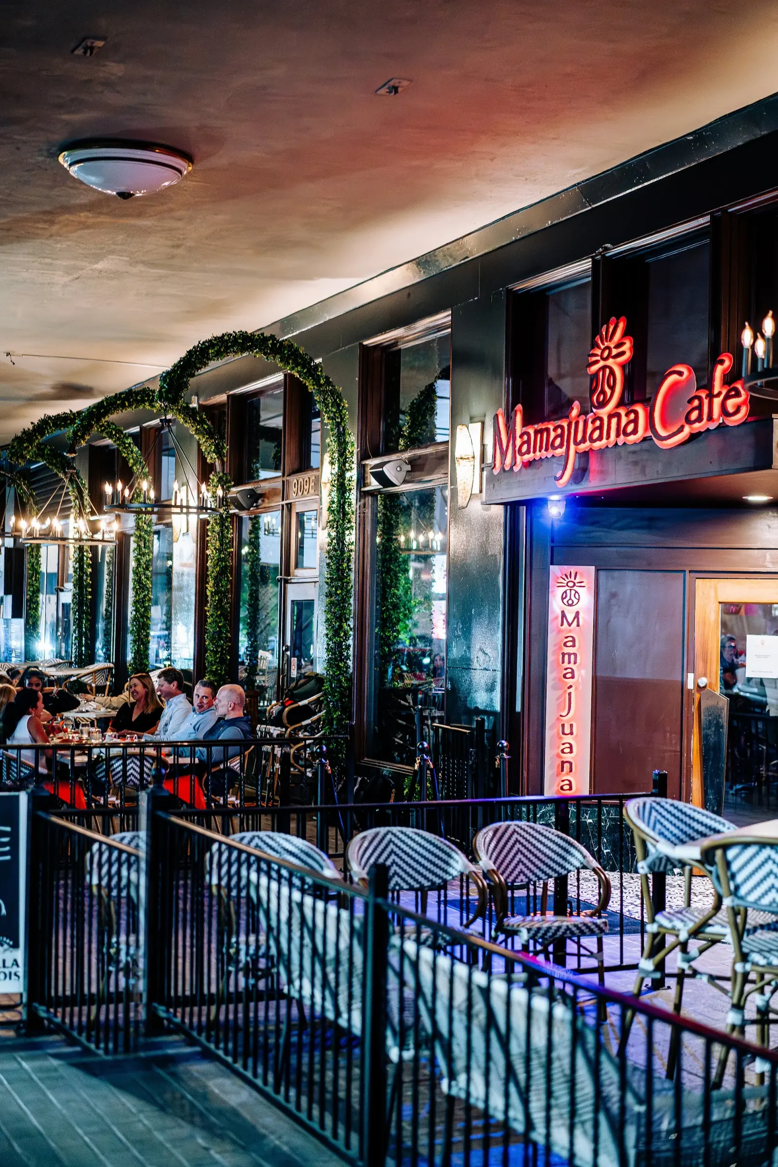 Evening patio and glowing Mamajuana Cafe neon sign, Latin bar in Houston