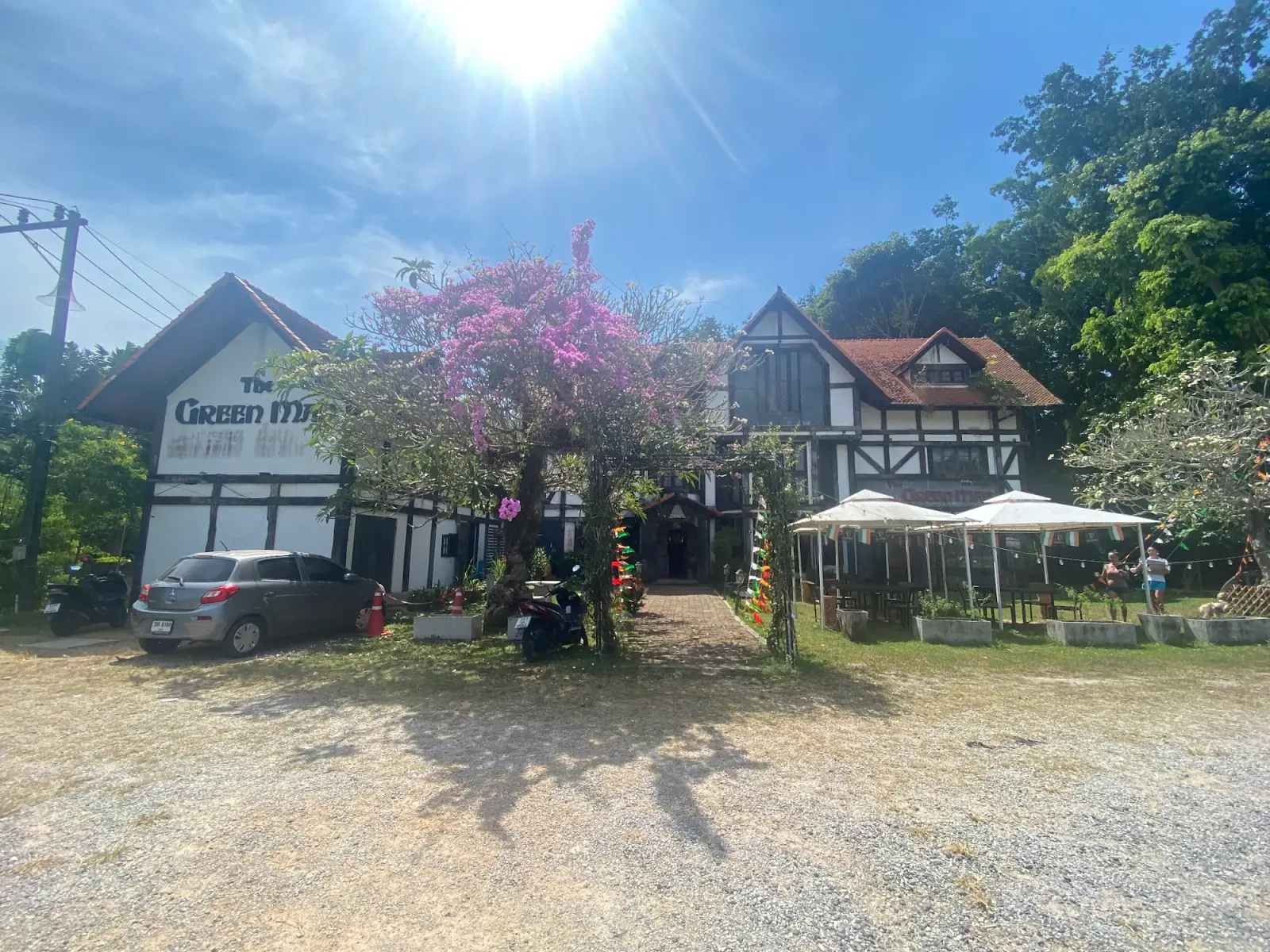 Daytime view of The Green Man pub exterior with garden seating in Phuket, Thailand