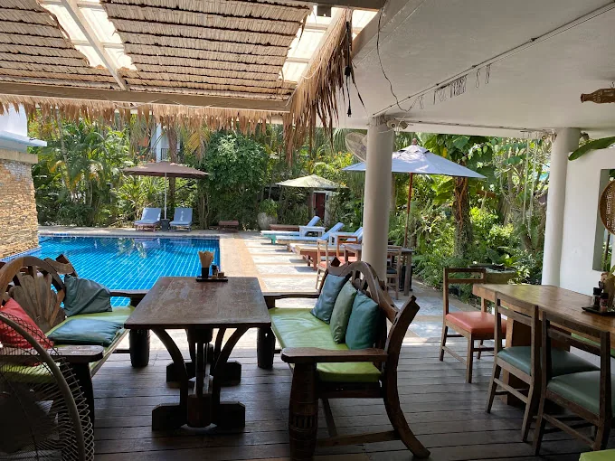 Greenlight Cafe restaurant exterior with swimming pool surrounded by tropical gardens