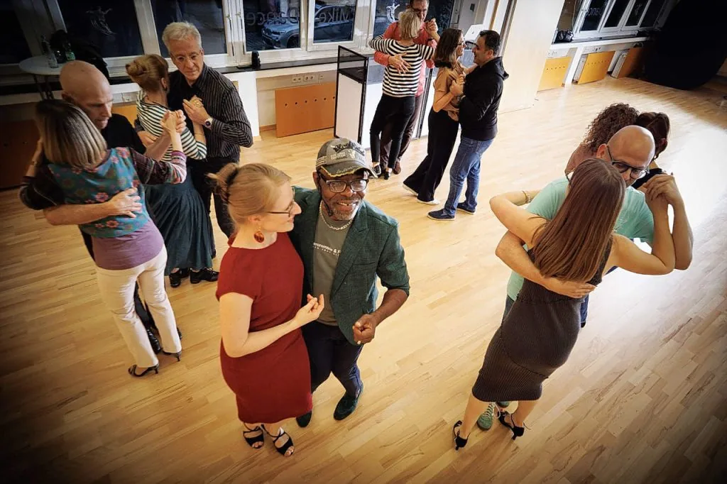 Multiple couples social dancing on the wooden dance floor at Mike Dance Tanzschule Munich