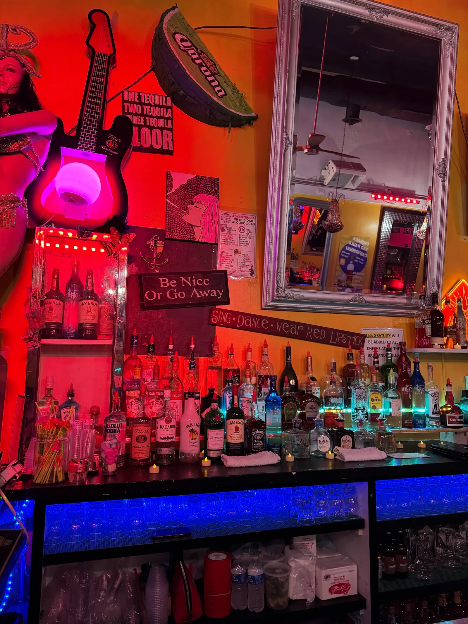 Cafe Citron's bar wall with neon Sing Dance Wear Red signage and illuminated bottle shelf in Washington, D.C.