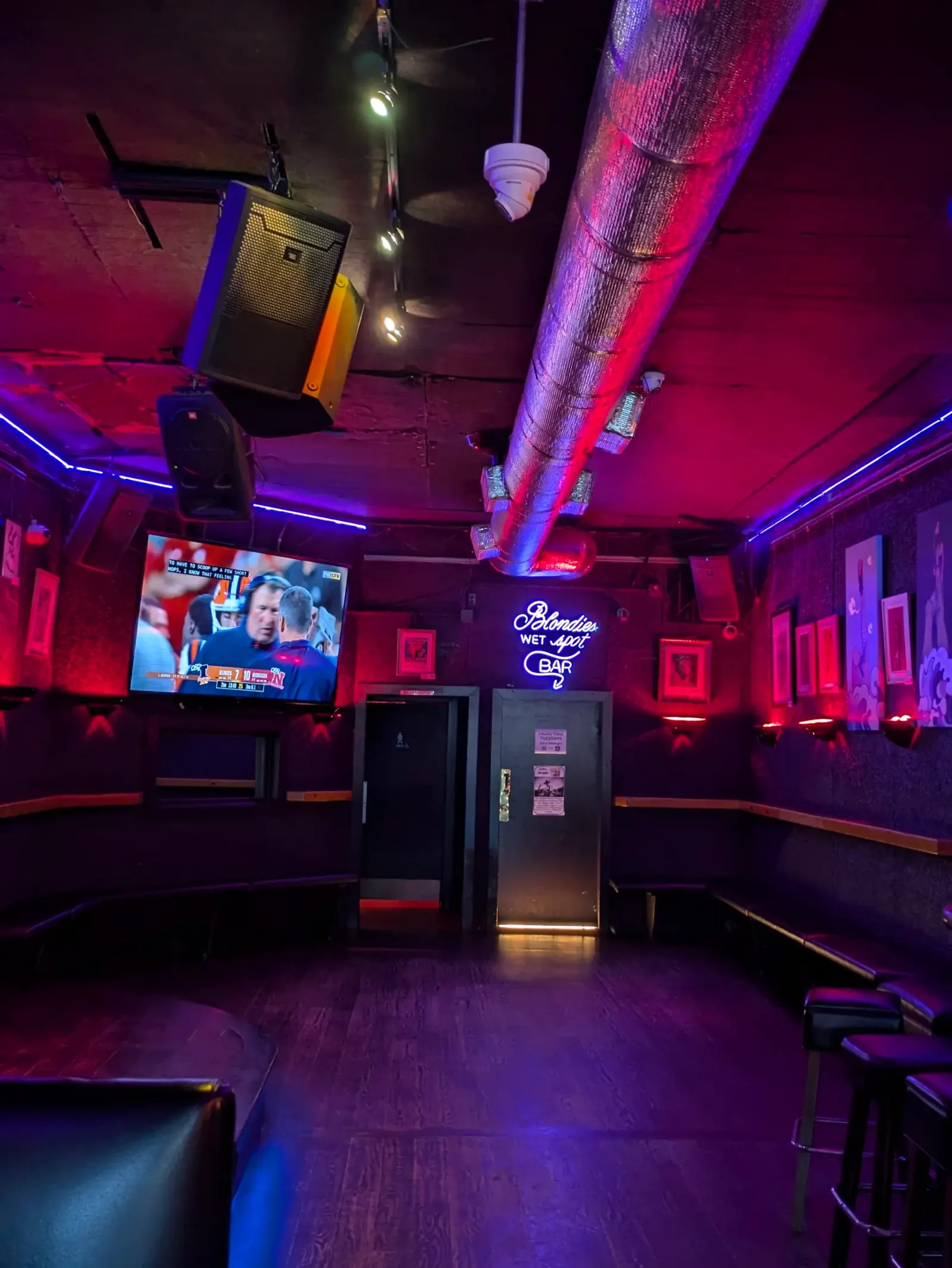 Interior of Blondie's Bar San Francisco with neon Wet Spot Bar sign red and blue club lighting and lounge seating