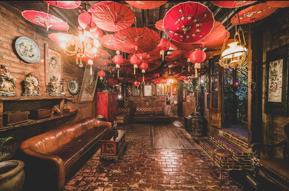 Eclectic interior with red Chinese umbrellas and lanterns at La Favela Bali