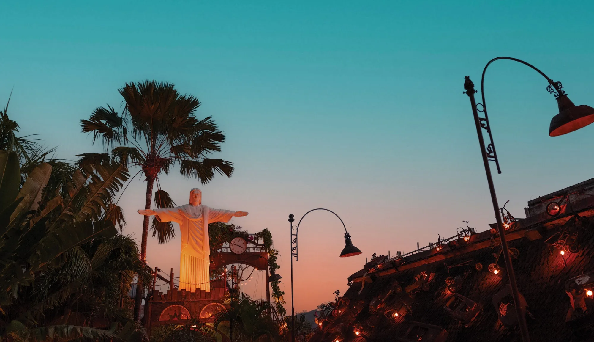Christ the Redeemer replica at sunset in La Favela Bali's Rio-themed garden