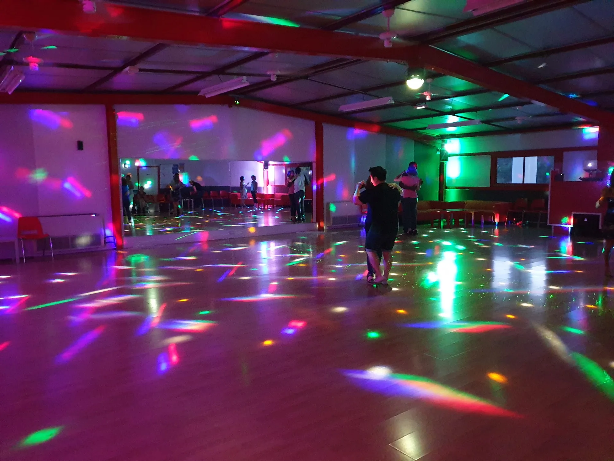 Couples dancing on the lit floor at Salle Le Temple Pessac with colourful lights