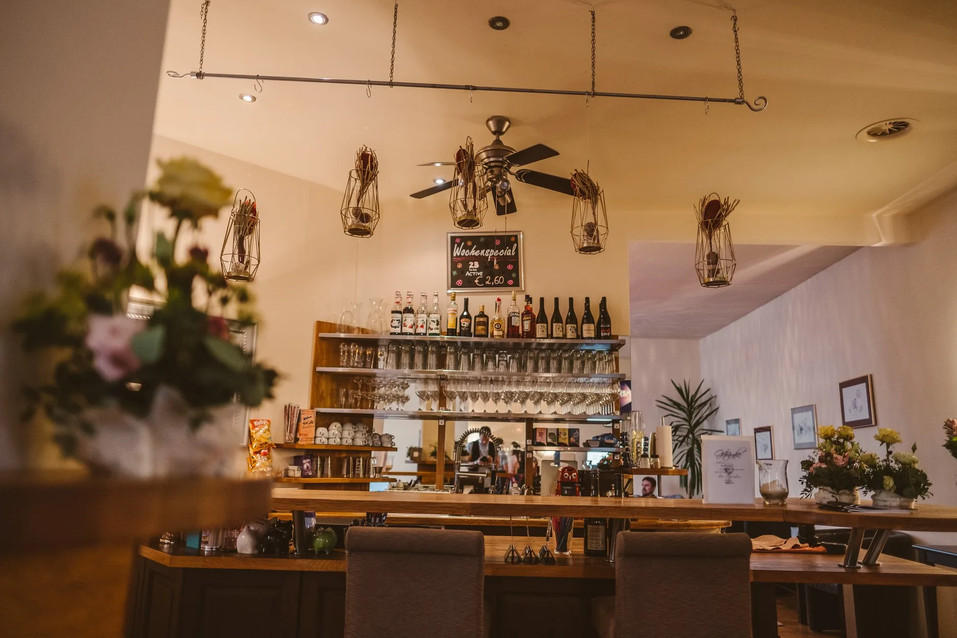 Warm-lit bar area with bottles and hanging lanterns at Tanzschule Conny and Dado in Graz