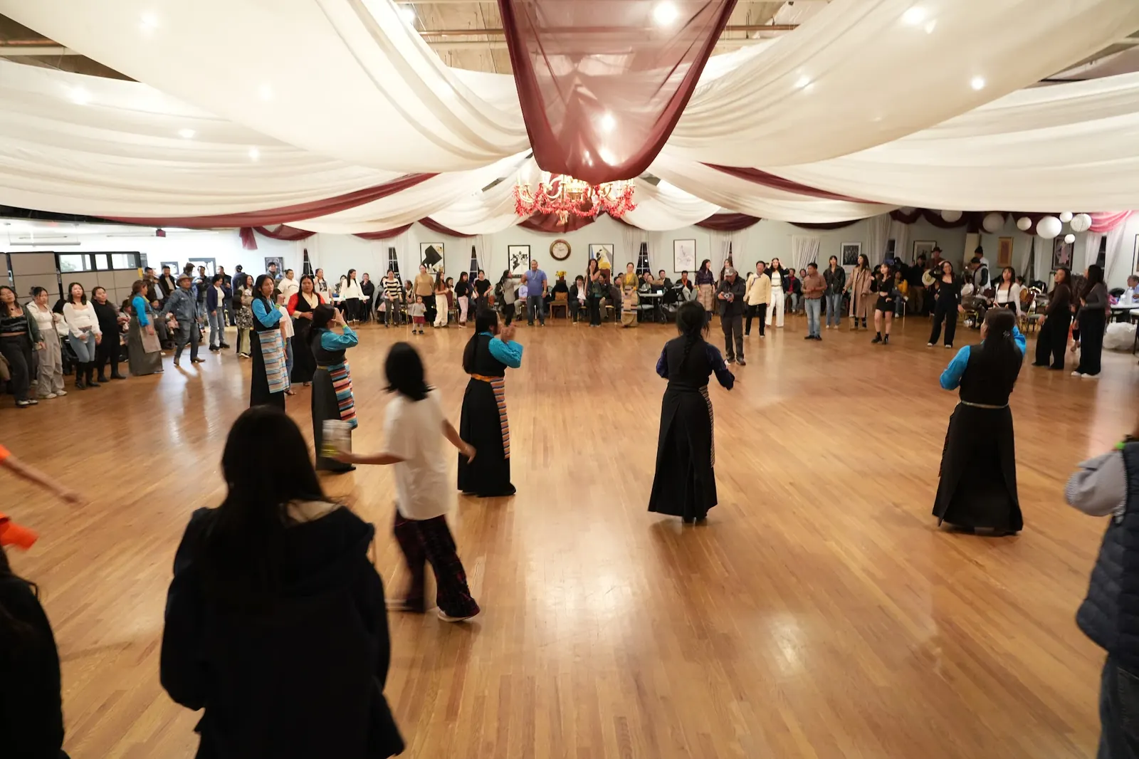 Dancers in traditional dress on the wooden floor under draped ceiling at The Avalon Ballroom