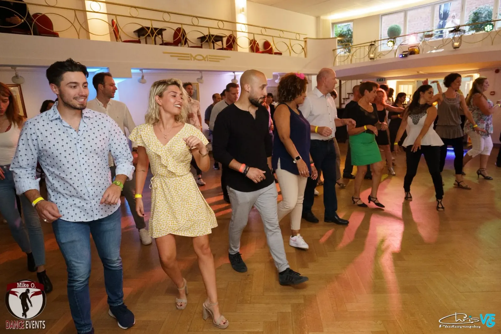 O'Dance Brussels — couples salsa dancing on the parquet floor with disco lighting