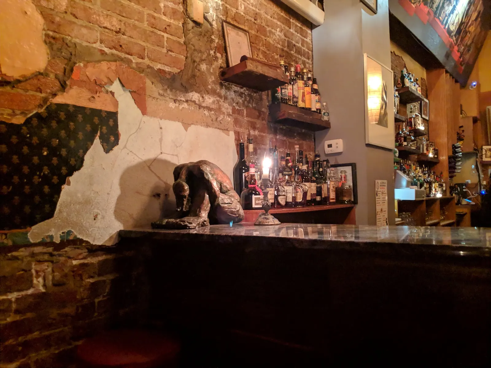 Bar counter and bottle shelves against exposed brick inside Bossa Bistro and Lounge in Washington