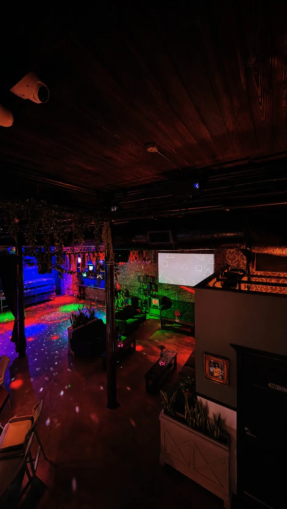 Dance floor at Distrito Federal in Houston lit by coloured lights with lounge seating behind