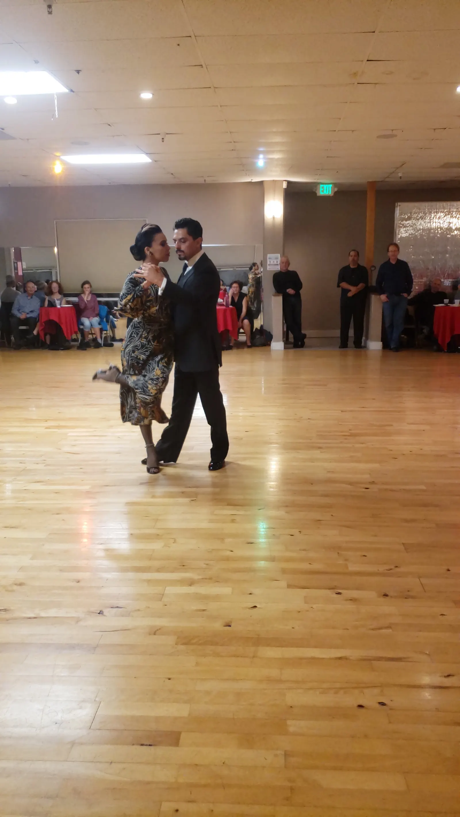 A couple dancing on the wooden floor at Dance Boulevard while seated guests watch