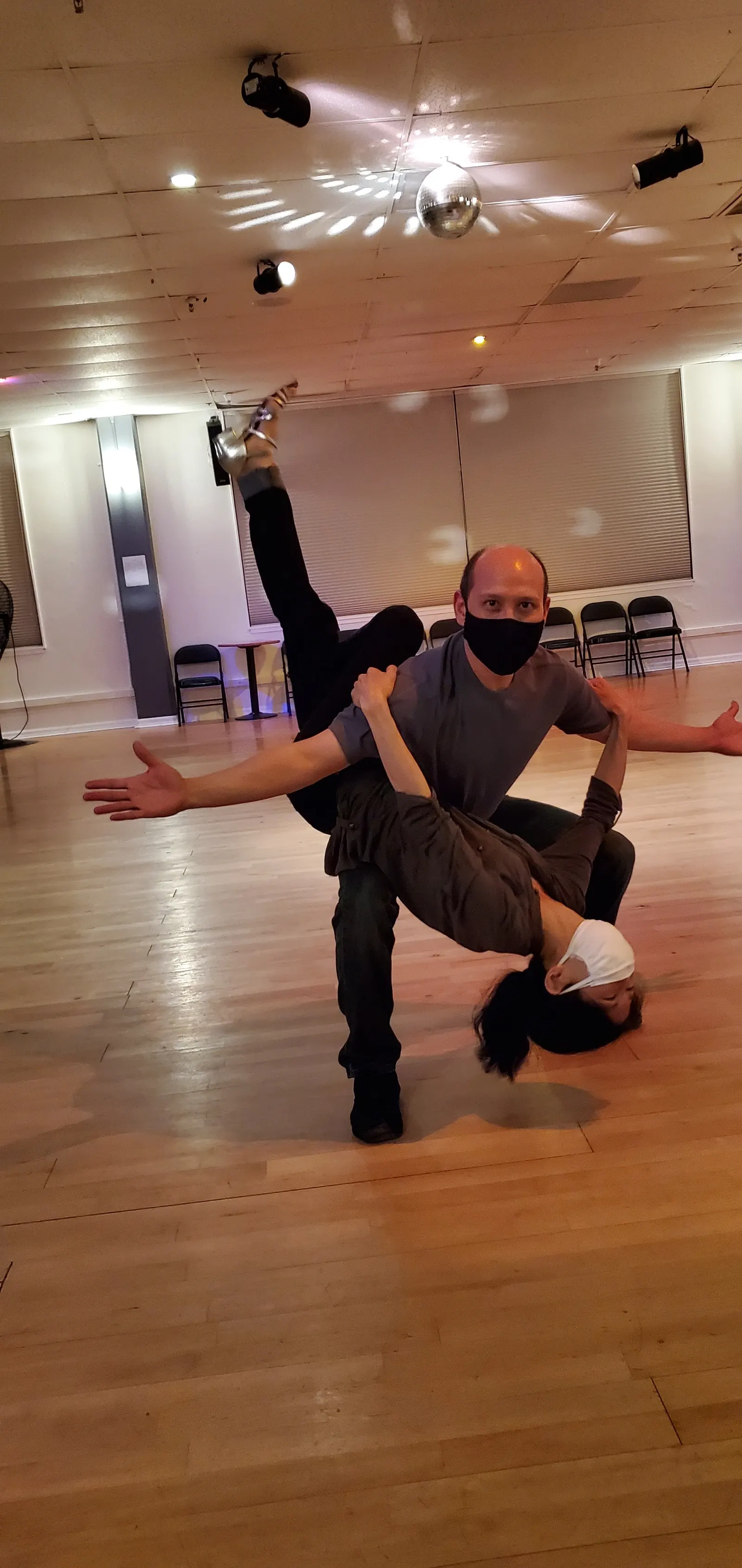 Dancers in a lift under the mirror ball on the wooden floor at Dance Boulevard
