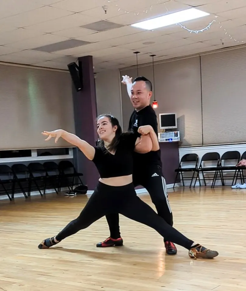 Two dancers posing mid figure on the wooden studio floor at Dance Boulevard, San Jose