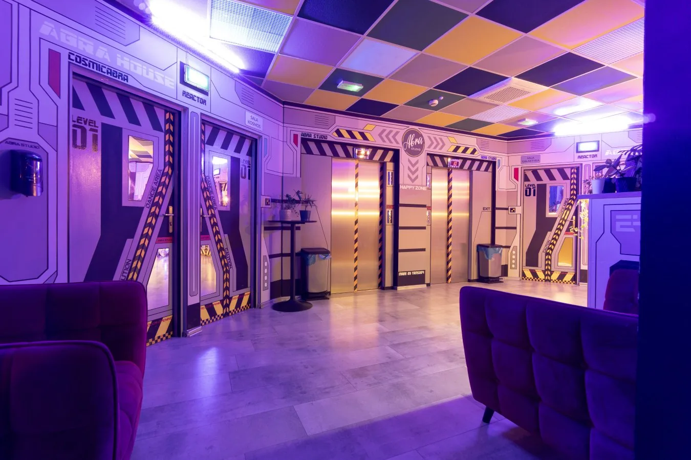 Abra Studio futuristic space-themed lobby with neon lighting and dance hall entrances in Warsaw