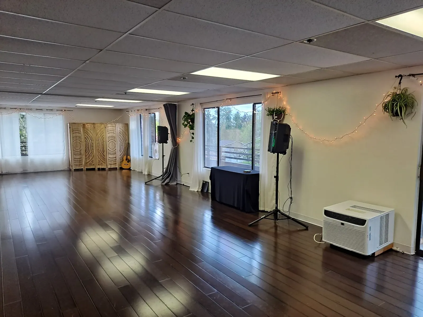 Interior of the Bravo Dance School studio with wood floor, mirrors and string lights