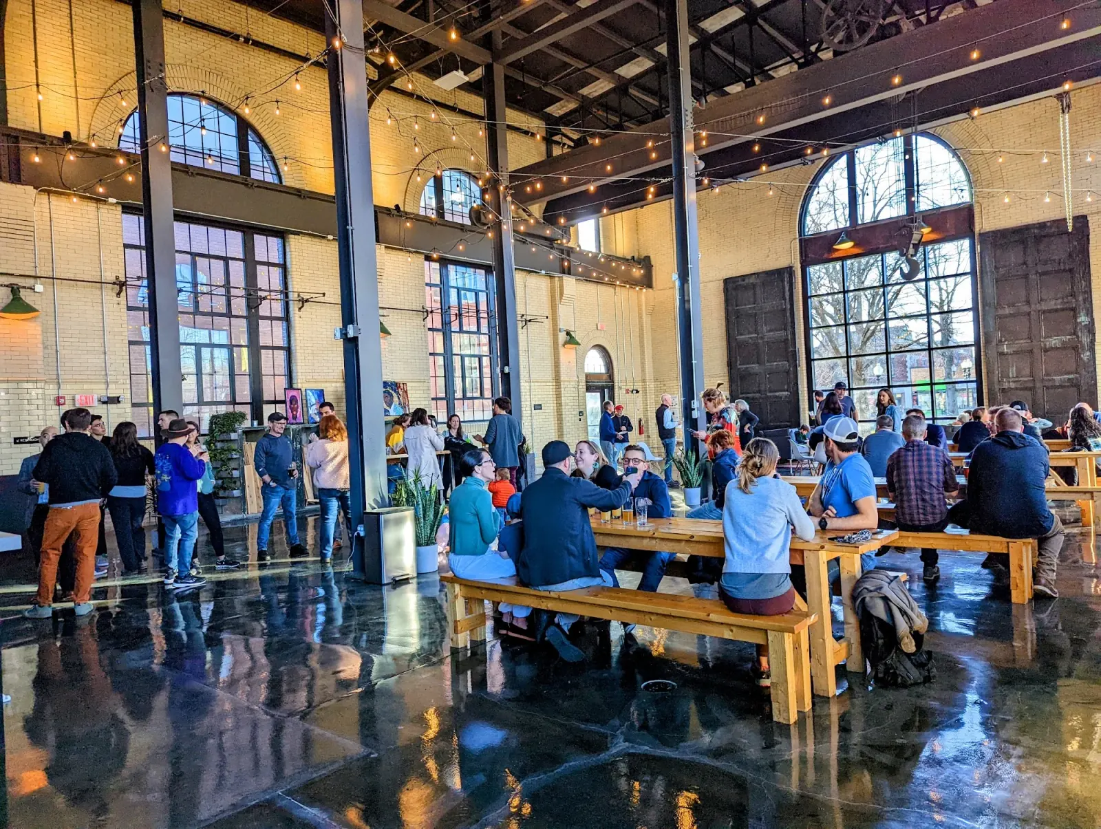 Crowd gathered under string lights at The Substation Boston, social event in the brick-and-arched-window venue