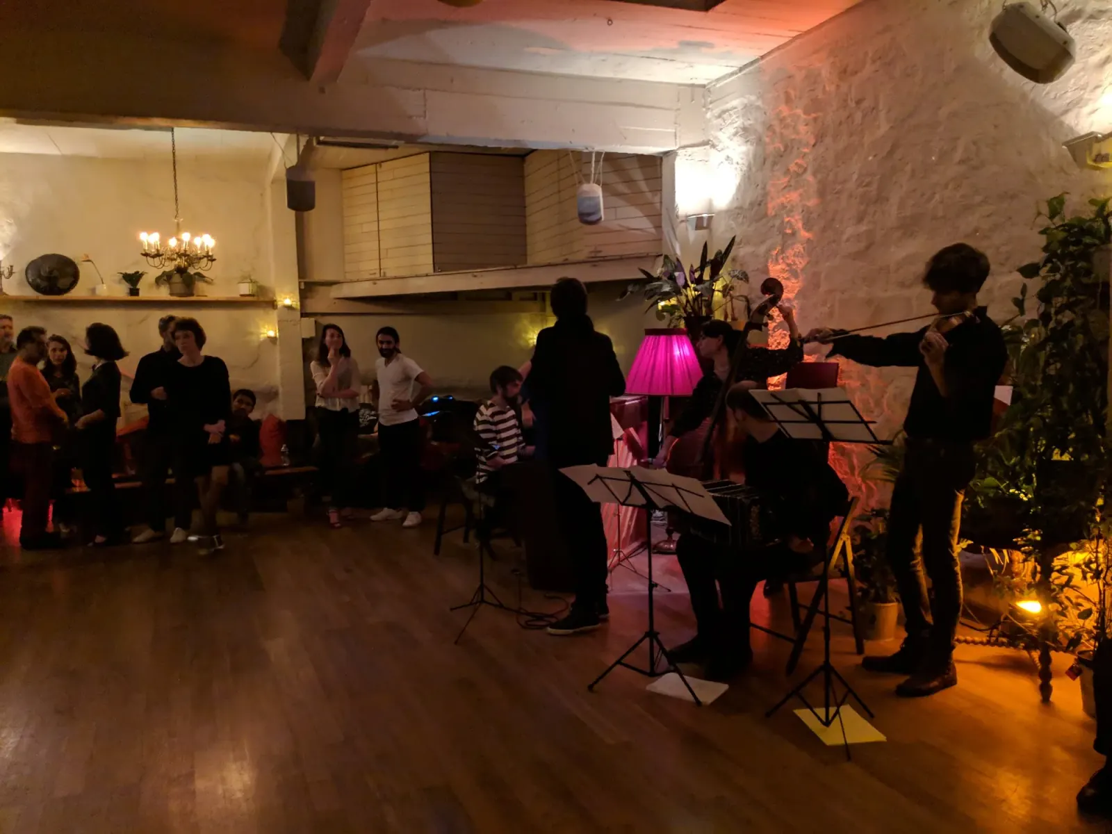 String quartet performing at Loft Lechapelais with audience watching in the candlelit space