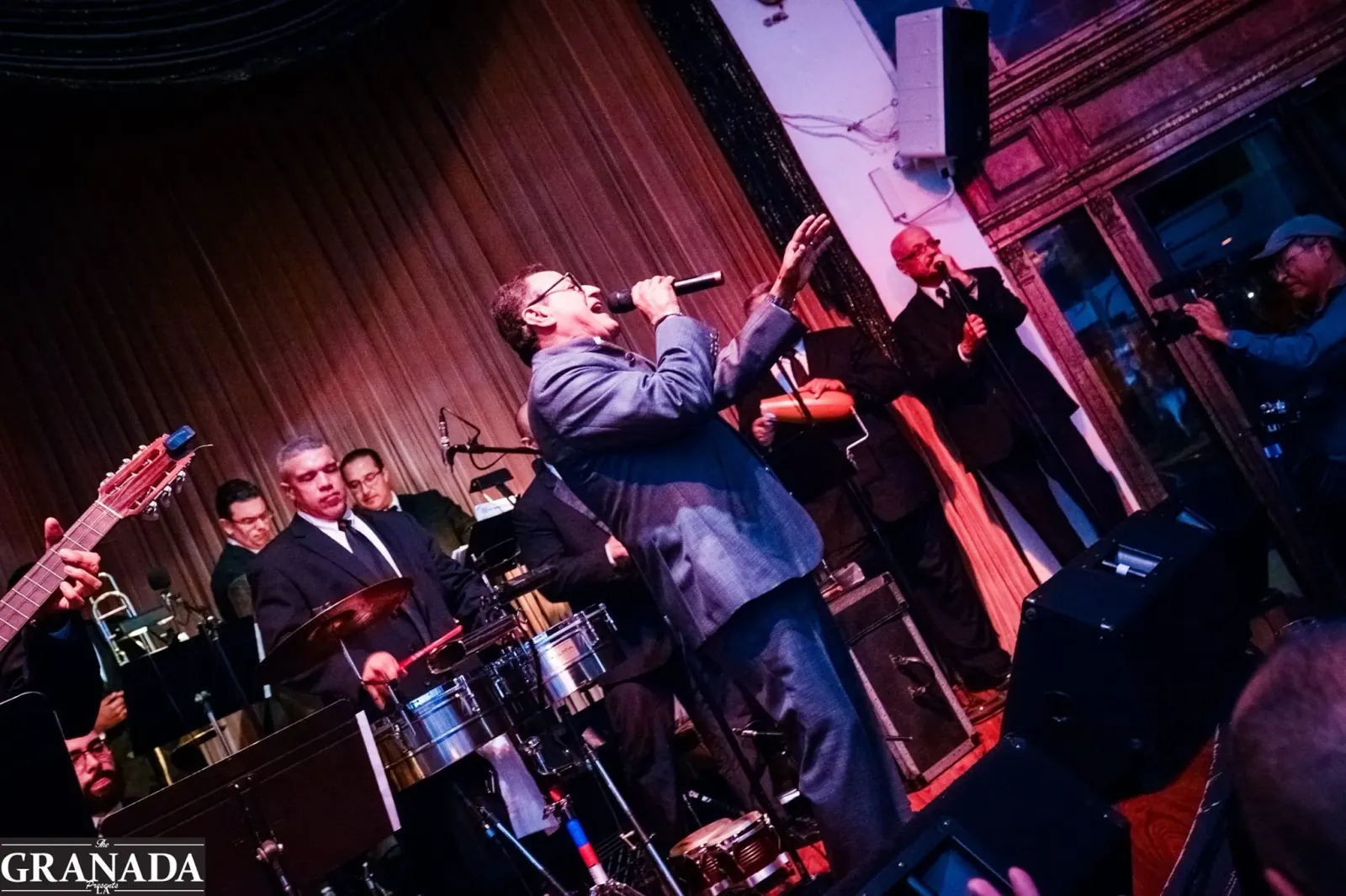 Live Latin band performing on stage with a singer and percussionists at The Granada LA, Los Angeles