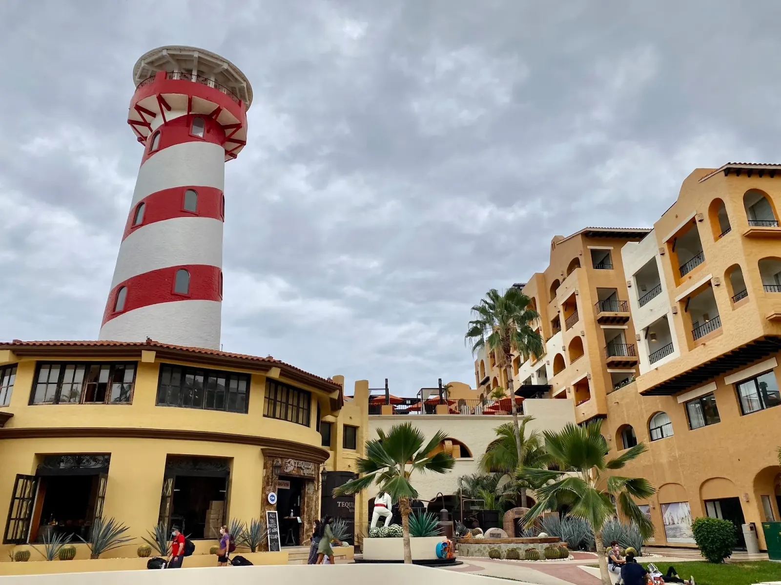 Red and white striped lighthouse tower at Tesoro Los Cabos resort with the venue buildings