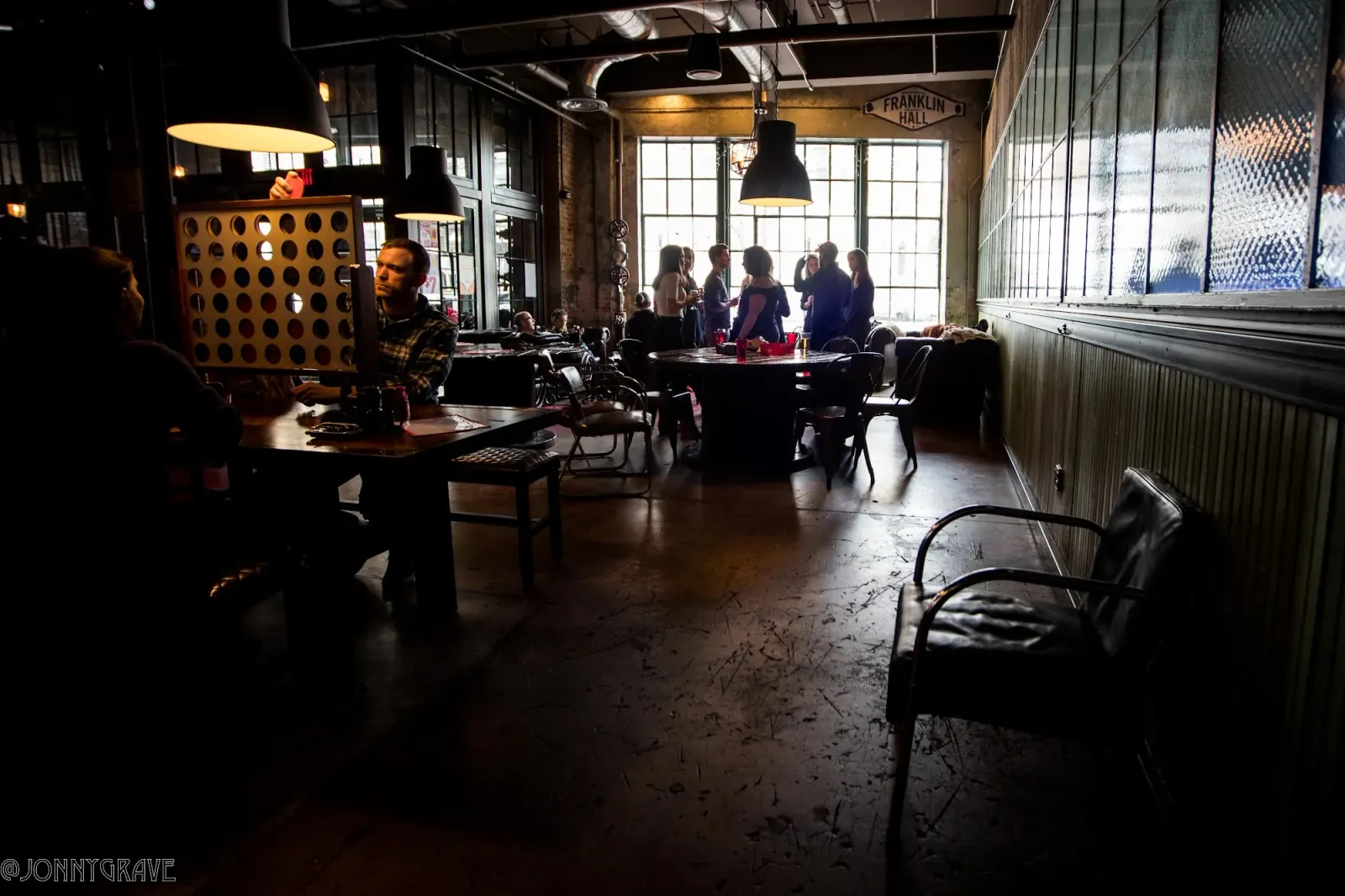 Industrial interior of Franklin Hall in Washington, D.C. with patrons and visible Franklin Hall sign