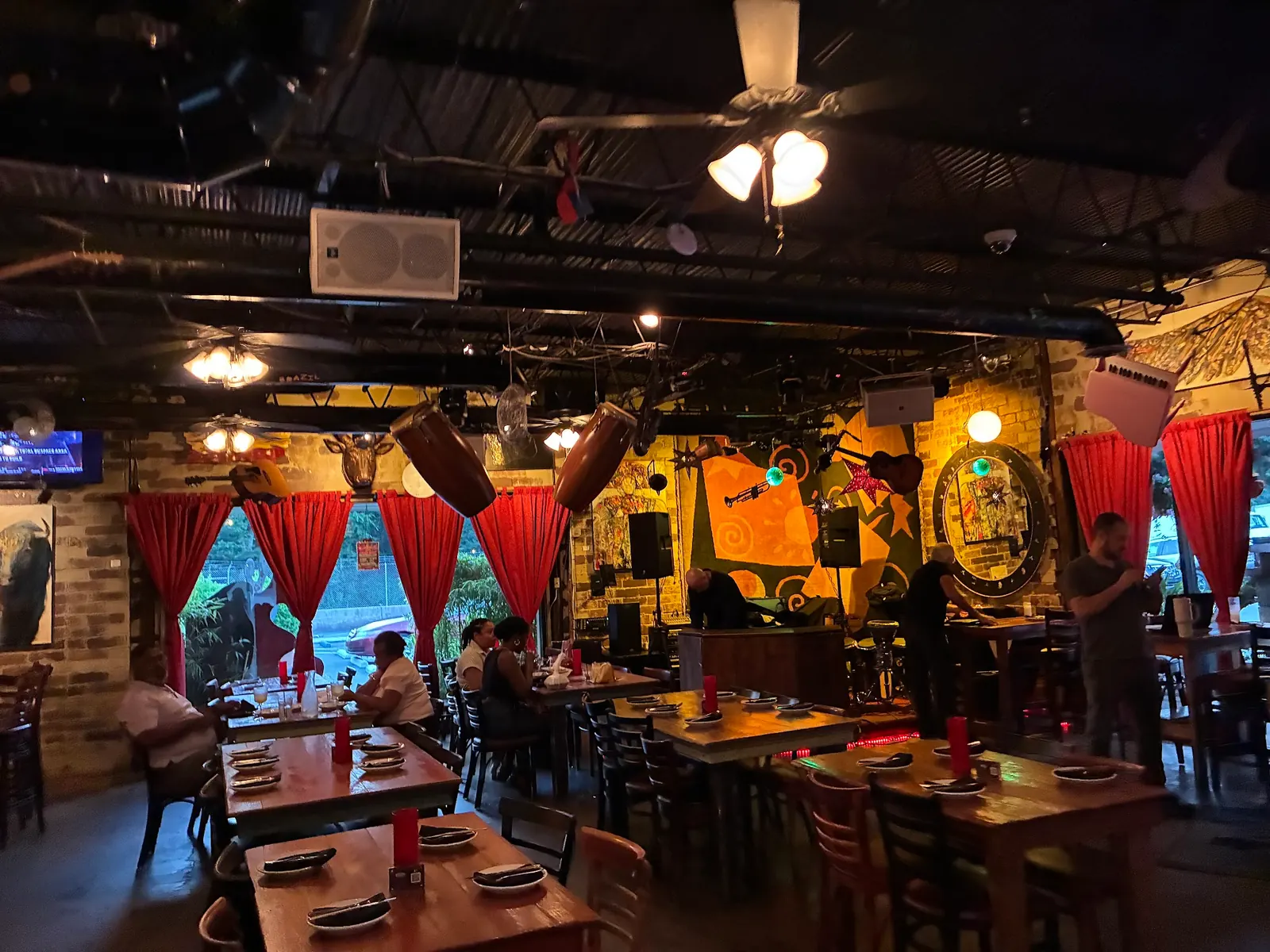 Stage area and open floor at Eclipse di Luna in Atlanta with congas and speakers above the tables