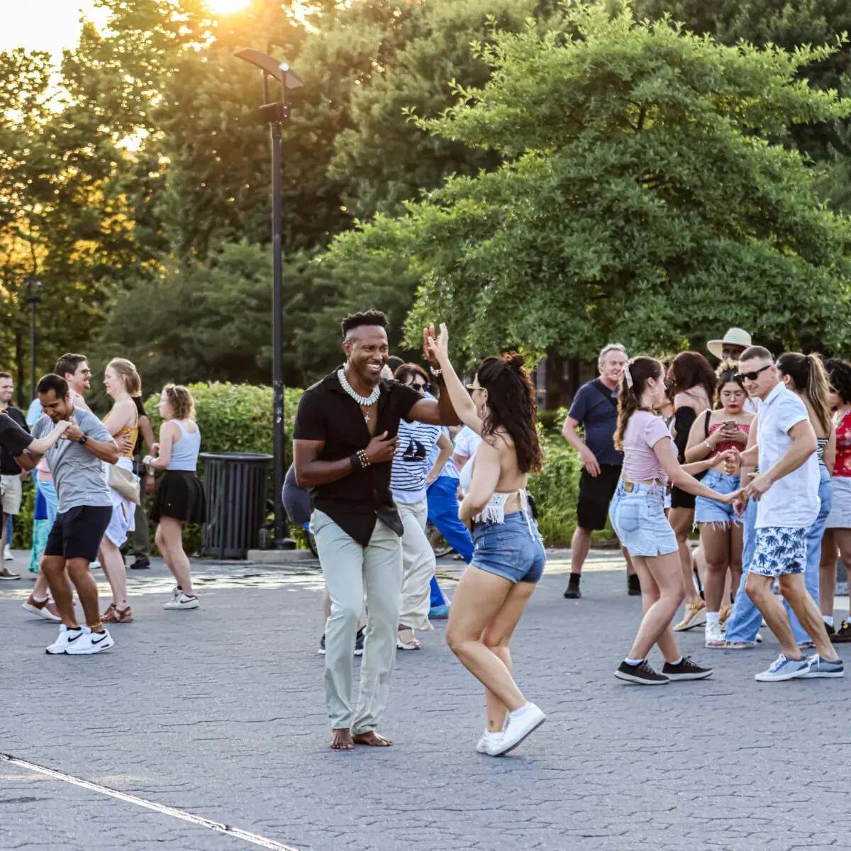 People partner-dancing outdoors at golden hour at the Georgetown Waterfront social, Washington DC