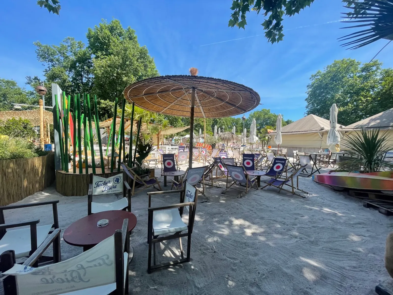 Sandy outdoor beach bar area at Lieblingsstrand Nürnberg with thatched parasol and tropical decor