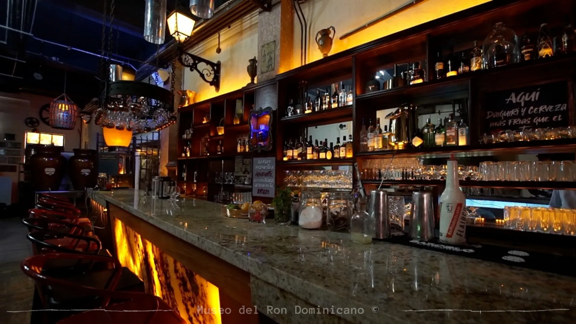Atmospheric bar interior with warm lighting and rum bottle display at Bar Museo del Ron Dominicano