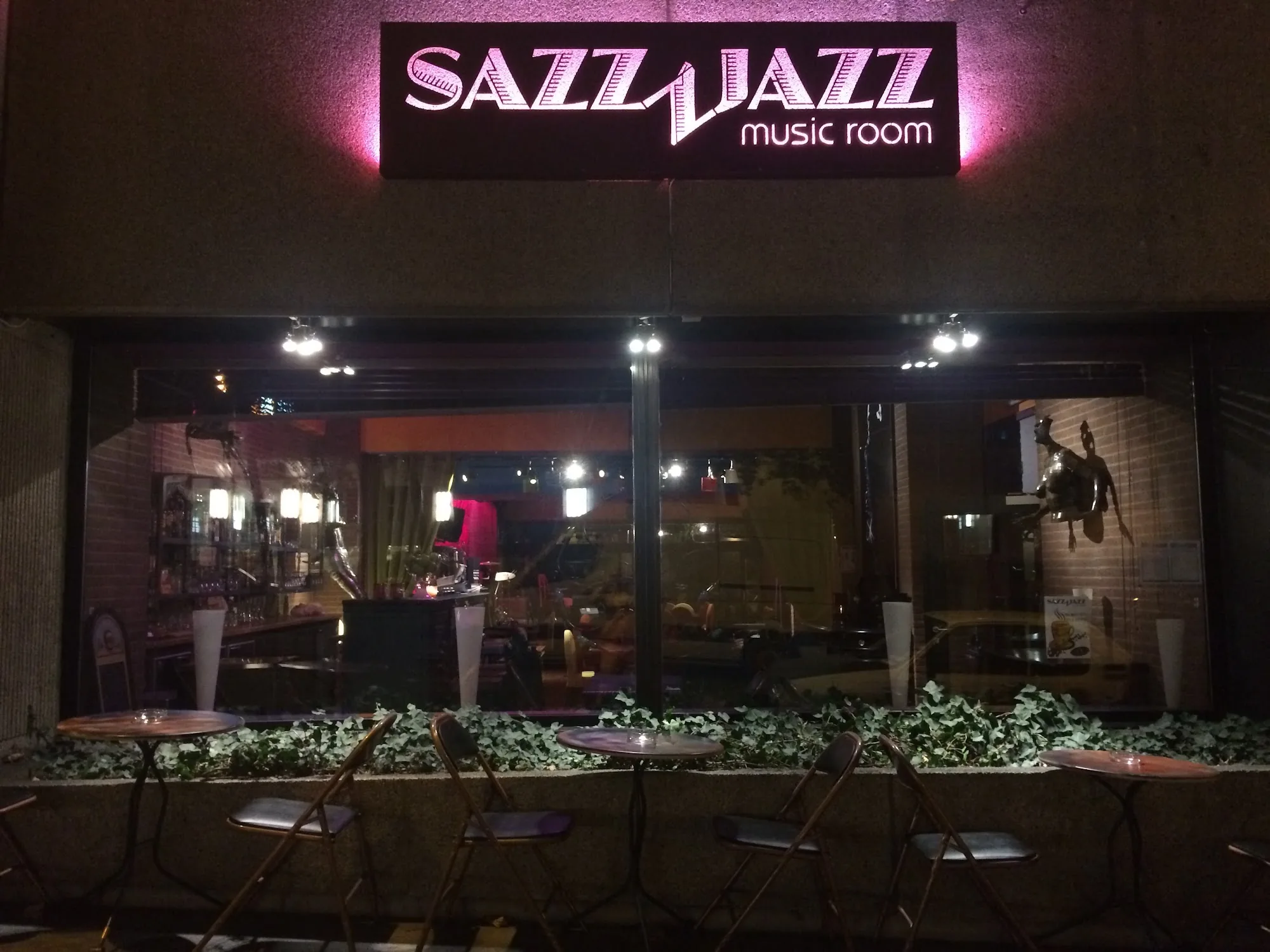 Illuminated Sazz Jazz music room signage above the entrance of The Embassy Room Brussels at night