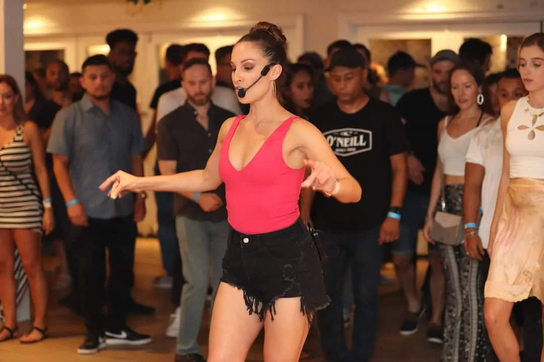 Dance instructor leading a bachata class at The Victorian Los Angeles with students gathered around the dance floor