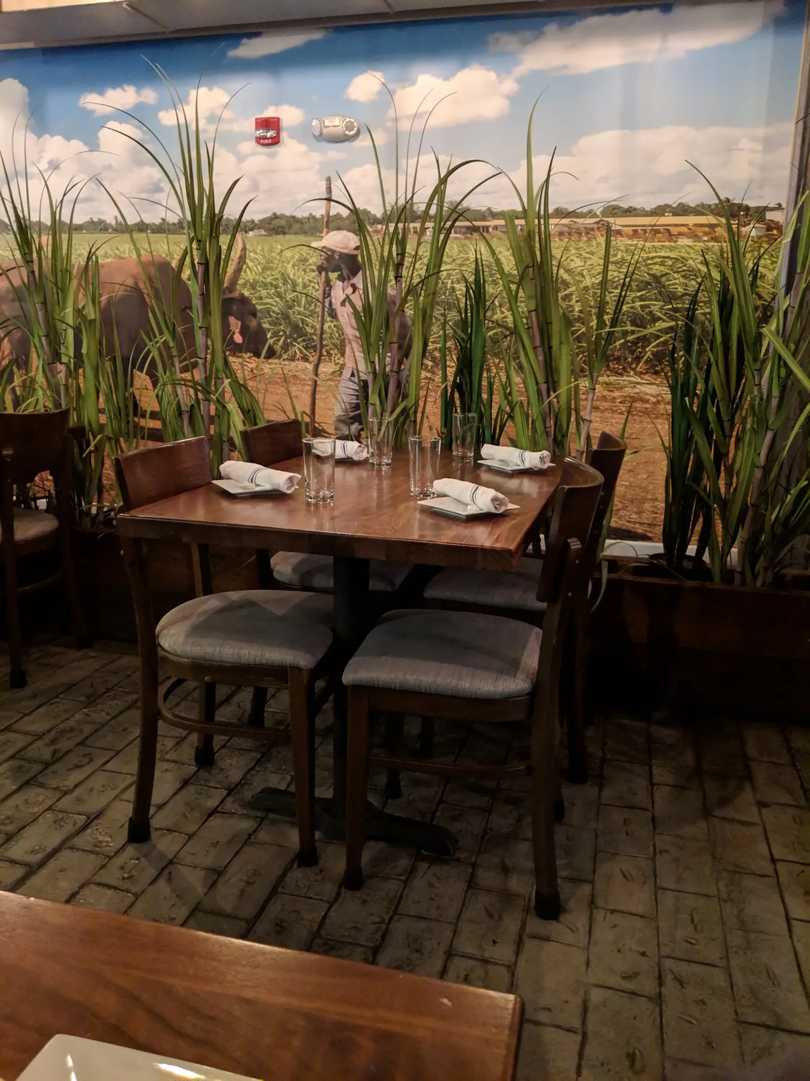 Table seating beside the Cuban sugarcane mural at La Fabrica Central