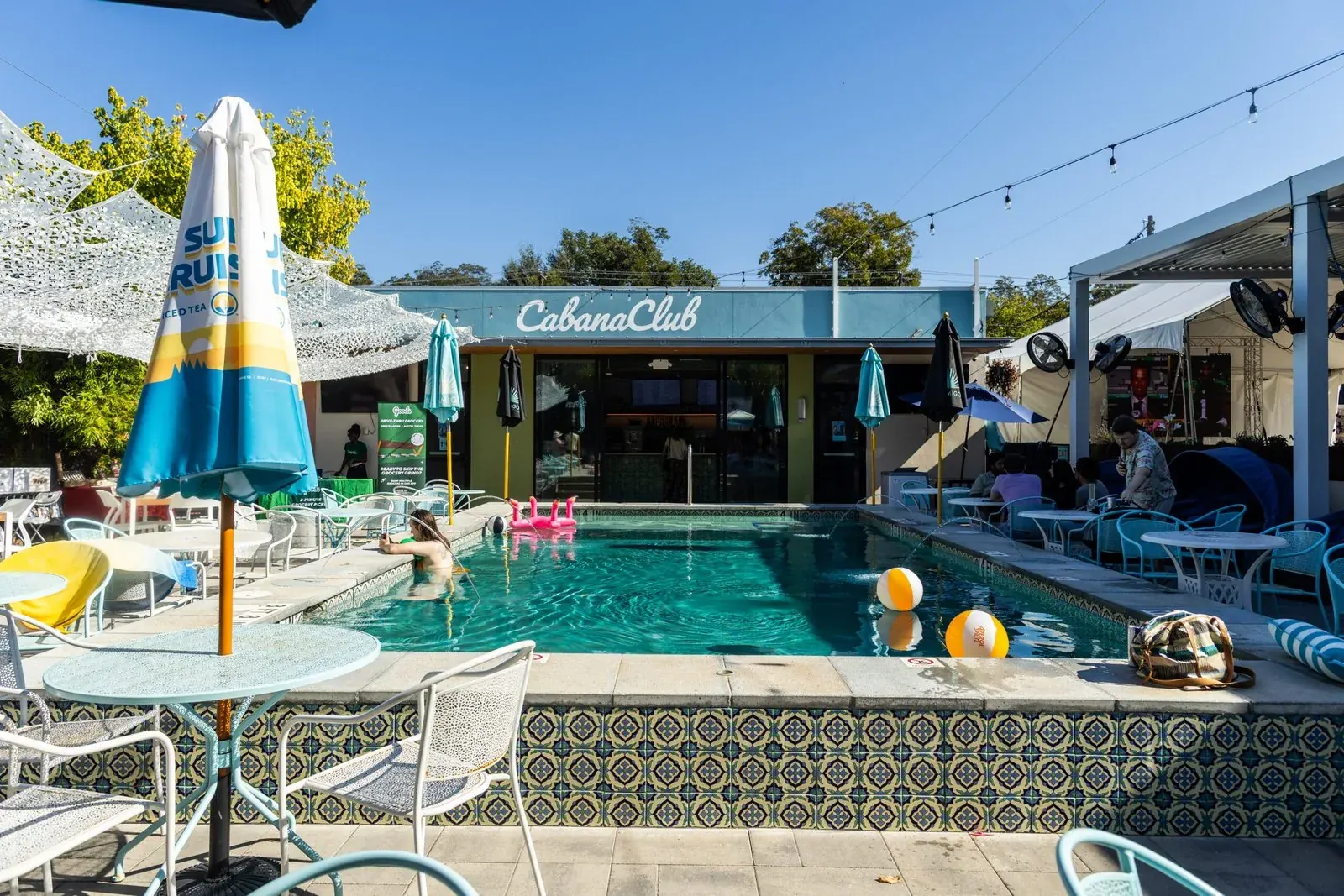 Cabana Club Austin exterior with tropical palm trees and resort-style cabana lounge area