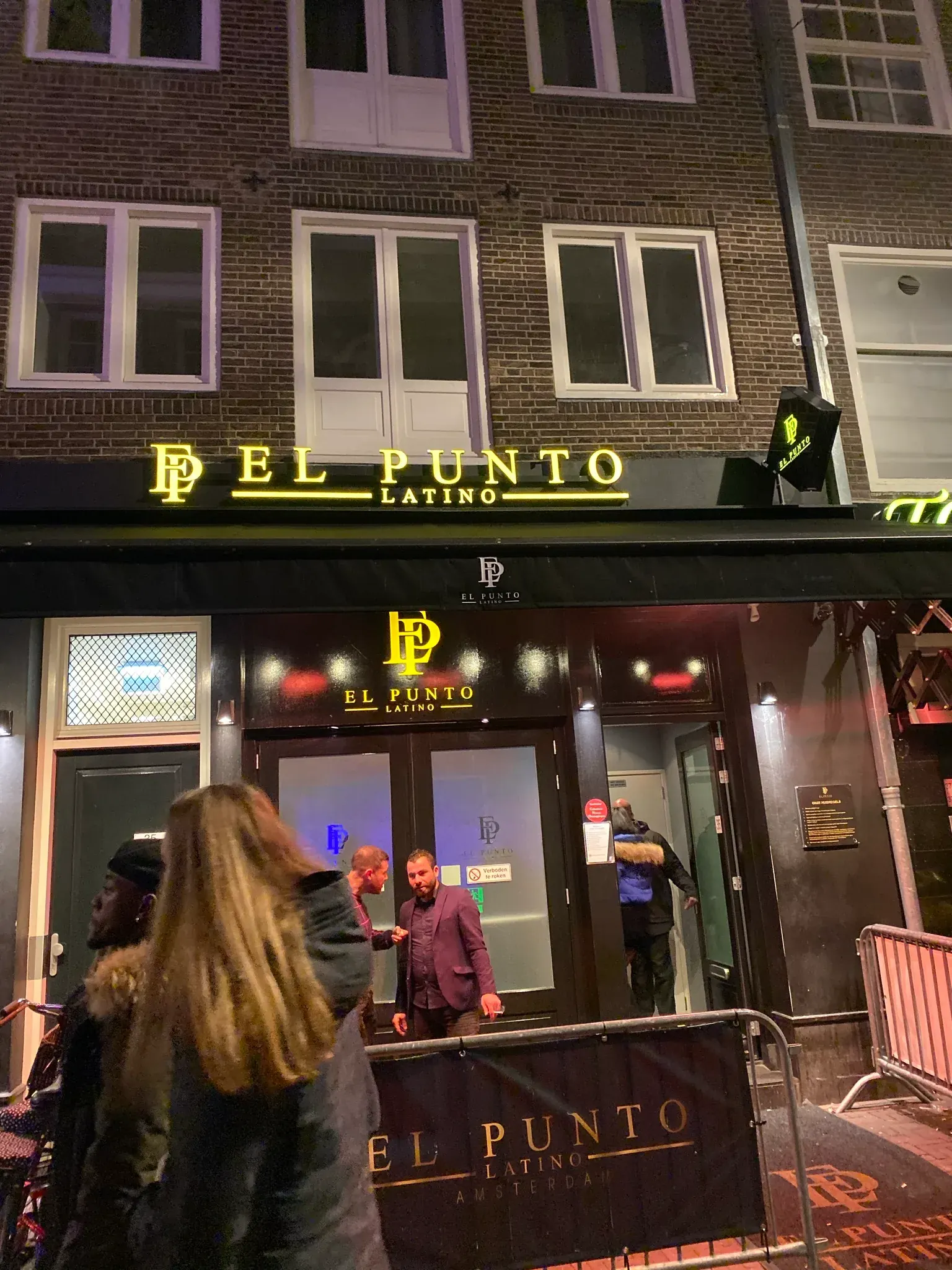 El Punto Latino Amsterdam venue entrance at night with branded sign and crowd outside
