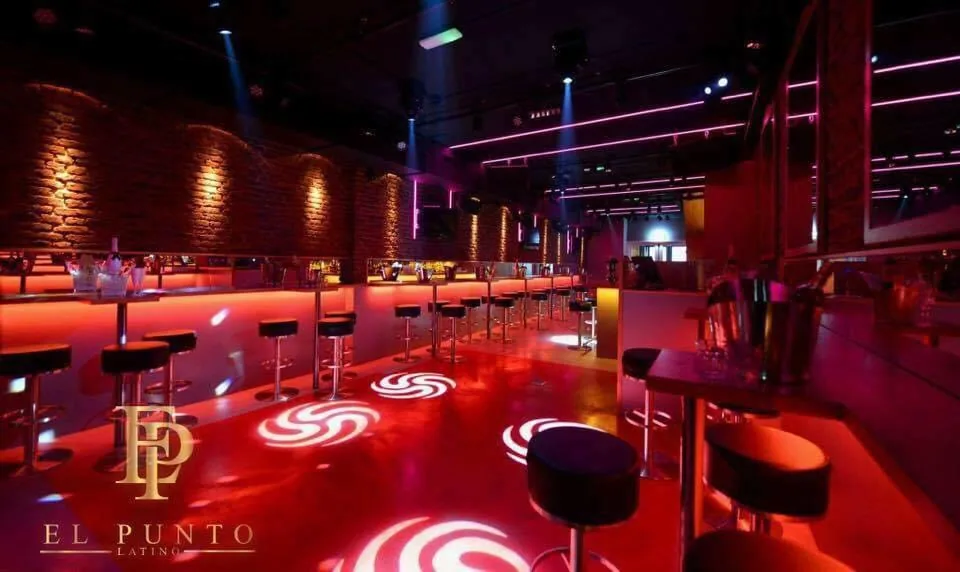 Dance floor at El Punto Latino Amsterdam lit in red with spinning light floor projections