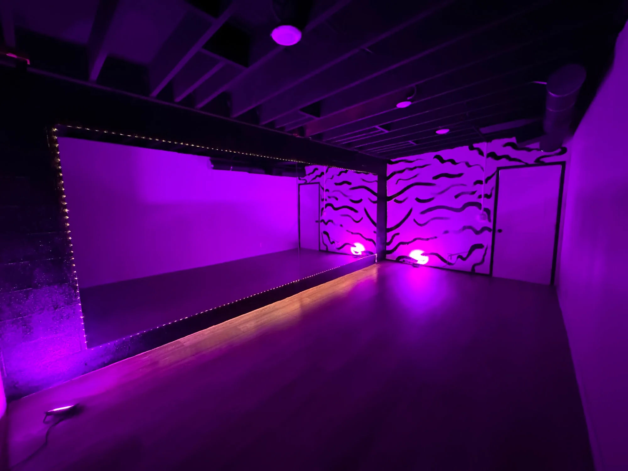 Mirrored studio room with purple lighting and wooden floor at RYG Dance Studio in North Hollywood