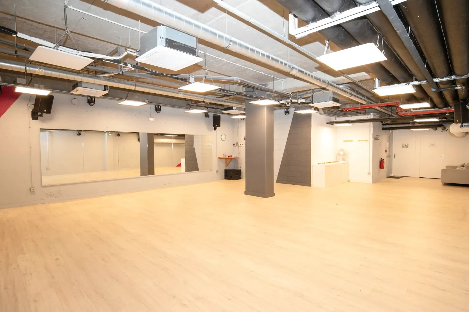 Spacious dance studio with wood floor and mirrored wall at Temple du Swing in Paris