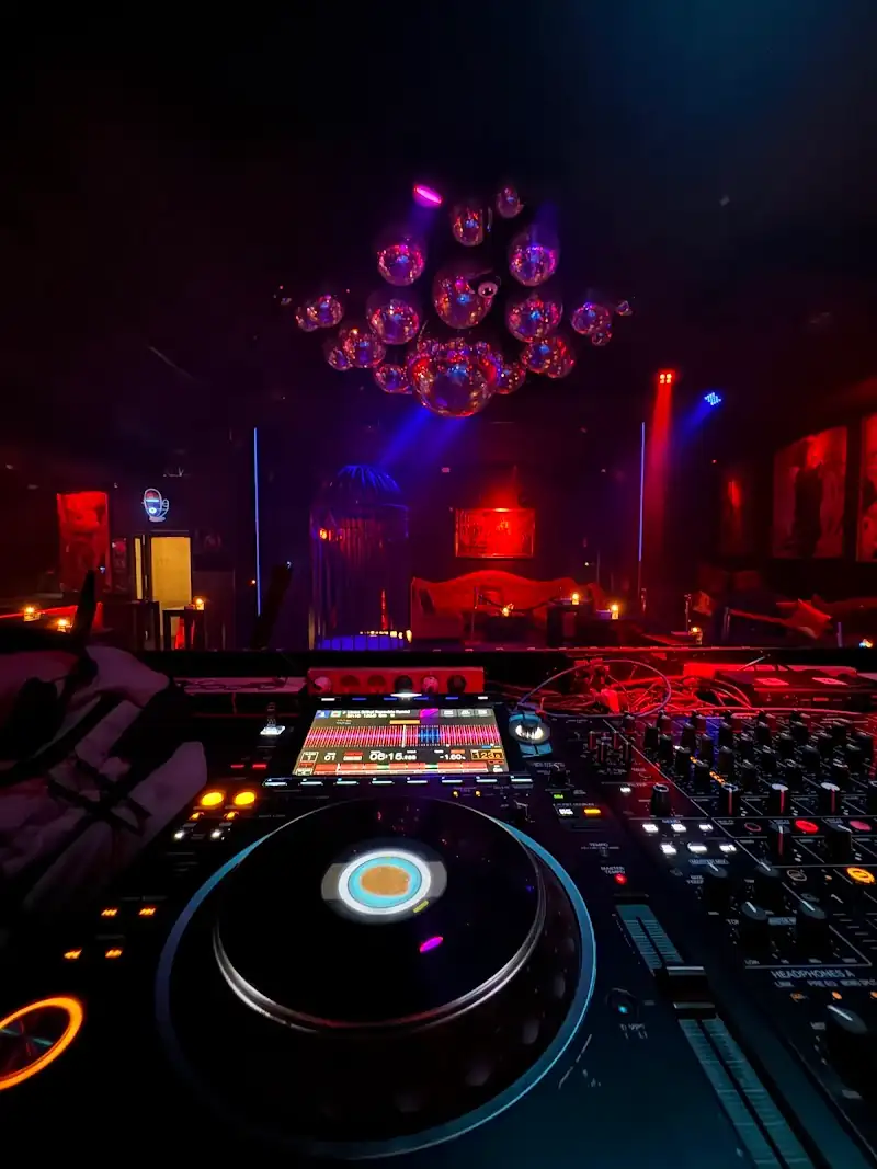 DJ booth with Pioneer decks at Red Ruby nightclub in Bali, overlooking the dance floor with mirror ball ceiling