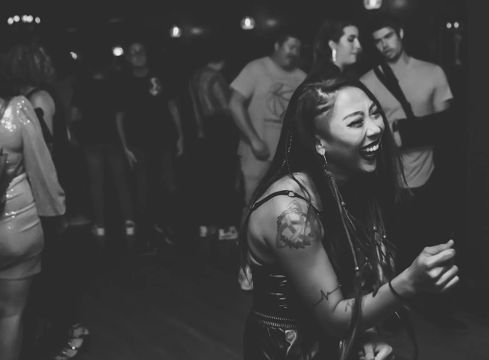 Black-and-white photo of people dancing on the wooden floor, a smiling woman in the foreground and a crowd behind, at Eighteenth Street Lounge, Washington.